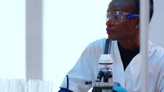 黑人女科学家利用显微镜进行近距离研究视频