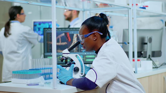 在现代实验室使用显微镜的非洲女科学家视频