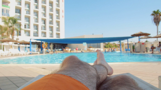 男人在游泳池的阳光下放松和晒日光浴视频