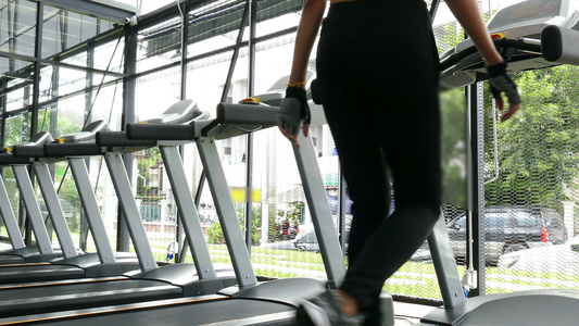 年轻女子在健身中心执行锻炼女运动员在健身房的跑步机视频