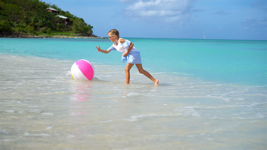 可爱的小女孩玩球在海滩上玩球孩子们夏季运动户外运动视频