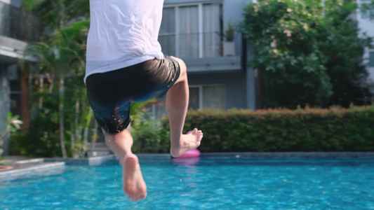亚斯人跳进酒店游泳池和水喷水他似乎享受并乐于户外活动视频