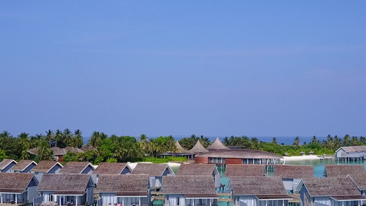 以清沙背景的蓝色海平面放松海岸海滩假日的海景和空中视频