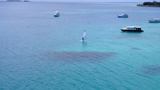 通过清水和白色沙尘背景的完美海湾海滩野生生物的空中视频