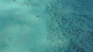 以白色沙子背景的蓝色海平面冲出海滩绕过一片蓝水洋11秒视频
