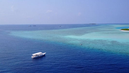 利用蓝水和清洁沙土背景进行海洋环礁湖海滩探险飞行的视频