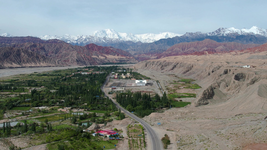 航拍新疆南部高原丹霞地貌与雪山公路视频视频