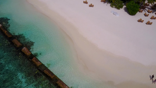 以蓝水和白色沙子背景的蓝水打破天堂湾海滩的空中无人驾驶视频