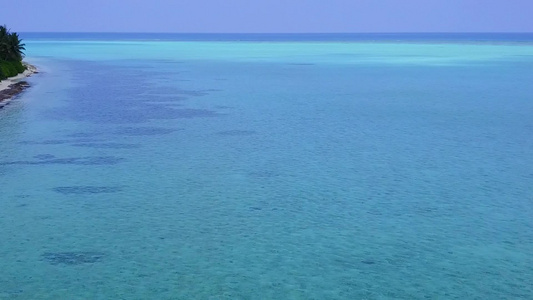 在干净的沙质背景的蓝色海洋中进行放松海岸海滩时间的视频