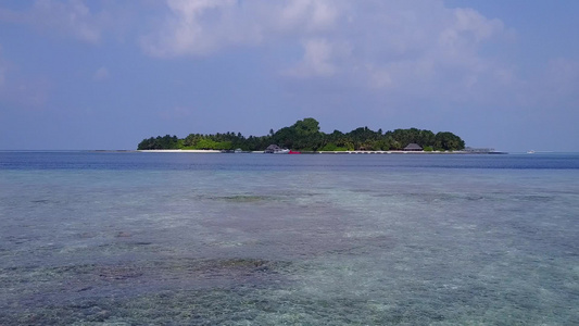 浅沙背景蓝海宁静海岸海滩度假的空中无人机全景视频