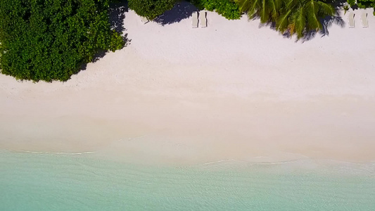 白沙背景蓝海完美海岸线海滩之旅的空中海景视频