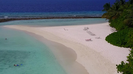 以蓝海和白沙为背景的美丽海岸海滩间休息的空中旅游视频