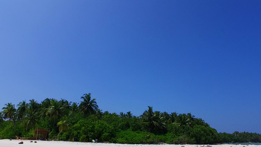 沿蓝海航行在珊瑚礁附近有白色沙子背景的蓝海经白沙背景视频