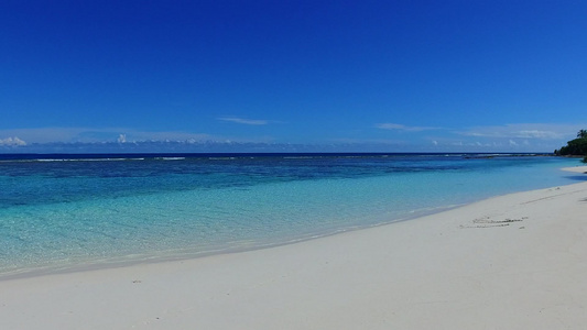 由阳光下白沙底的蓝色环礁湖构成的平静的旅游海滩假日视频