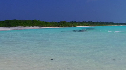 蓝色水和白沙背景的蓝水在海浪附近举行美丽的海滨海滩视频