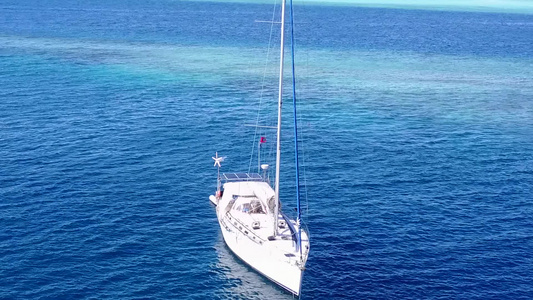 热带海岸海滩航行的温暖摘要蓝海和靠近波浪的白色沙滩视频