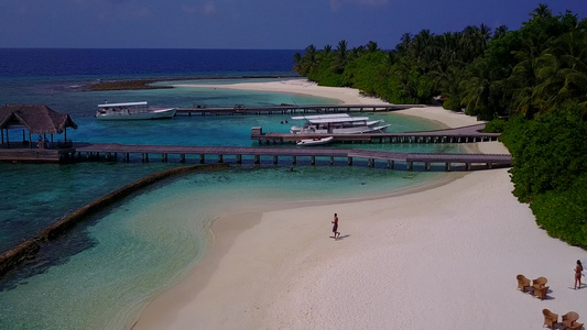 阳光下清澈的海洋和白沙背景的天堂度假村海滩之旅的浪漫视频