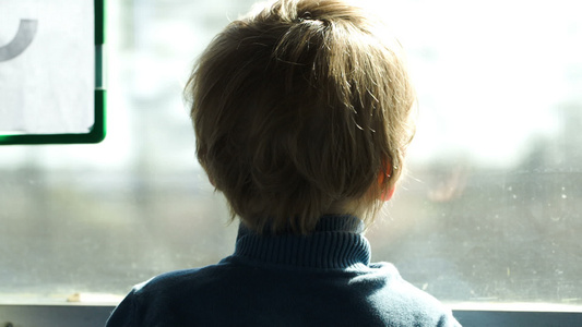 小男孩看着大巴或火车窗外的小男孩视频