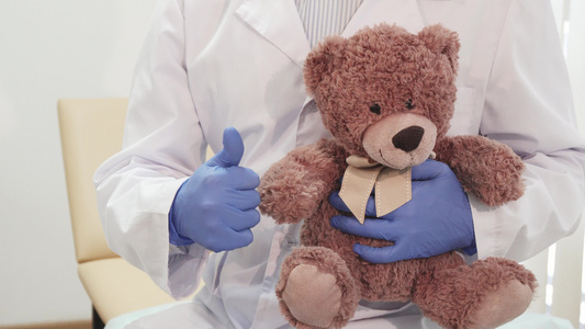 专业医生拿着一只泰迪熊露出拇指视频