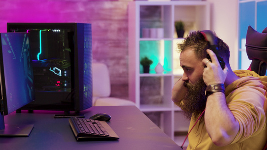 集中的男人在房间里用Pc玩电子游戏视频