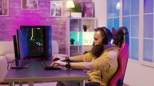 胡子长胡子的男人在一个有多彩的尼恩的房间玩电玩游戏视频