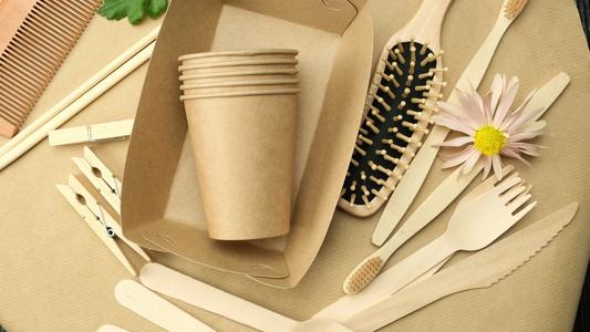 各种可回收的物品一次性纸杯和棕色背景上的木叉子视频