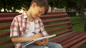 小男孩在板凳上写笔记8秒视频