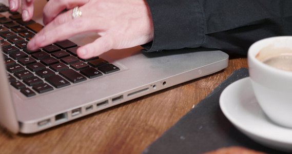 在笔记本电脑键盘上打字的妇女手贴近镜头视频