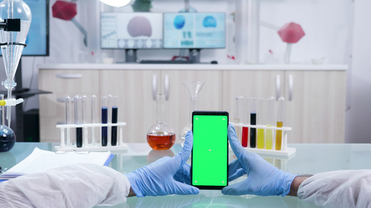 科学家拿着绿色屏幕智能手机的第一视角镜头视频