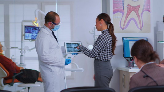在候诊室看牙医与女病人谈X光视频