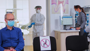 具有防护服的牙科医生在接待室分析牙齿X光检查20秒视频