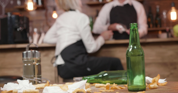 在一个封闭的酒吧中的脏桌子上的空啤酒瓶视频