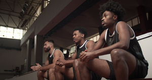 三个篮球运动员坐在一个板凳上观看比赛欢呼和鼓掌20秒视频