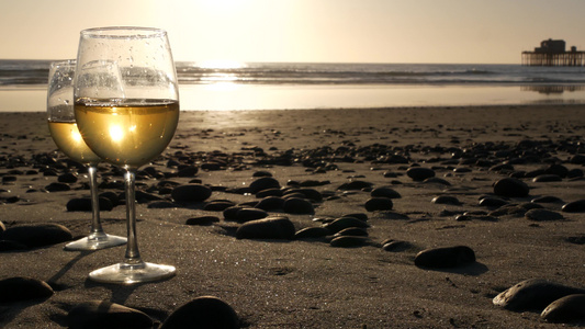 两杯红酒在海边一杯白葡萄酒用于浪漫约会海水日落波浪视频