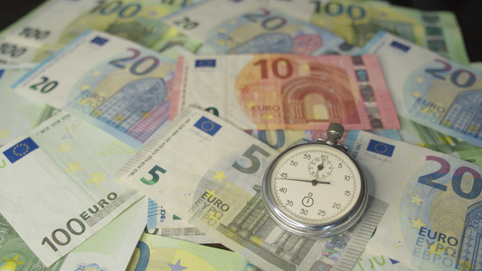 货币宏观拍摄手表位于钞票层的中心时钟时间是金钱视频