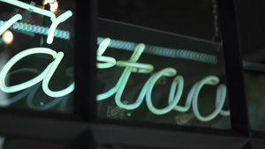 在理发店和纹身工作室窗户上的蓝色纹身灯符号6秒视频