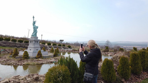 女性在拍摄自由雕像的纽约市微型模型17秒视频