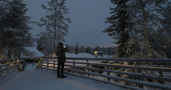 男子在晚上冬渡假站拍照片视频