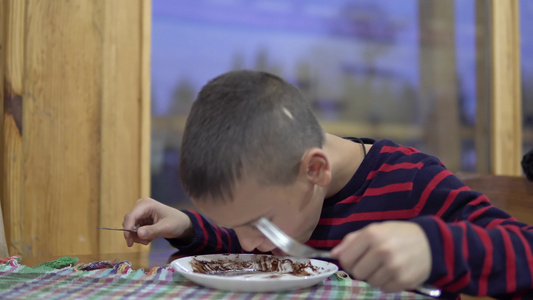 小男孩在餐厅里吃煎饼烤蛋糕煮美味的蛋糕做糖霜视频