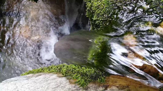 紧闭地看见水流的流光水从石头之间掉落而出流入石块之间视频