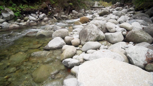 清晰的山河流小水落下弯曲着圆石石岩电影片段拍攝慢动作视频