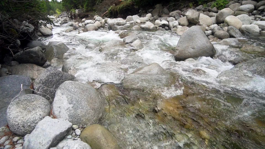 山川流小水落下弯曲着圆石石岩缓慢运动视频