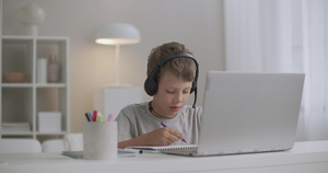 小男孩周末在家戴耳罩在线学习10秒视频