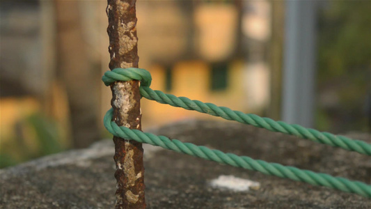 绳子被捆绑在栅栏柱上绳子被捆绑在与背景隔绝的生锈铁杆视频