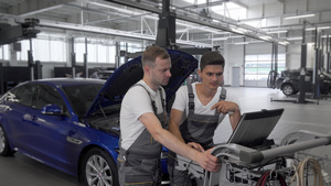 在汽车修理站使用计算机的成熟机械工及其助手车维修站12秒视频