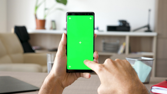 男人的手在滚动右在现代智能手机上绿色屏幕染色体模拟视频