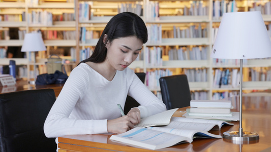 女大学生在图书馆看书写字视频