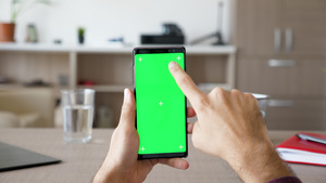 男人在客厅里拿着智能手机用绿色屏幕染色体模拟13秒视频