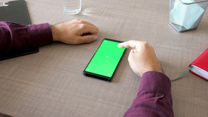 用绿色屏幕染色体制成的智能智能手机在桌上模拟男性手14秒视频