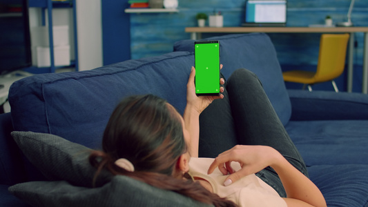 拥有智能手机并装配绿色屏幕的随意妇女视频